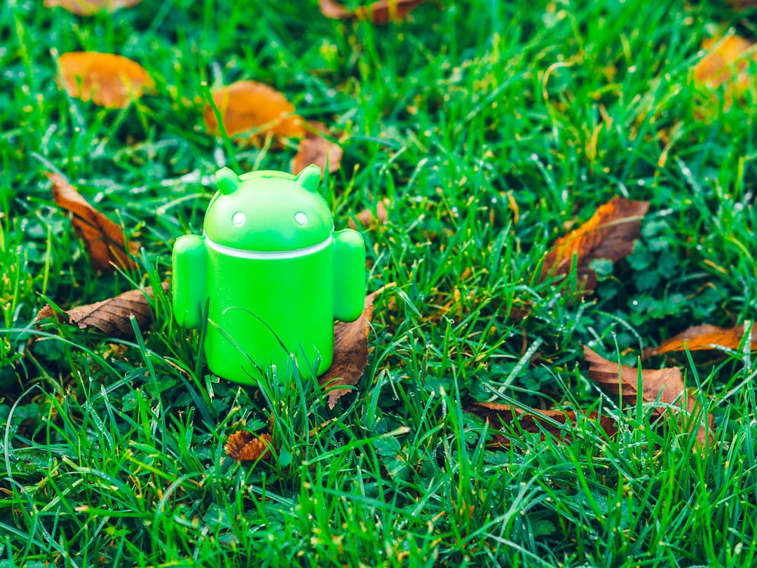 green Android robot toy on grass — Photo by Alexander London on Unsplash