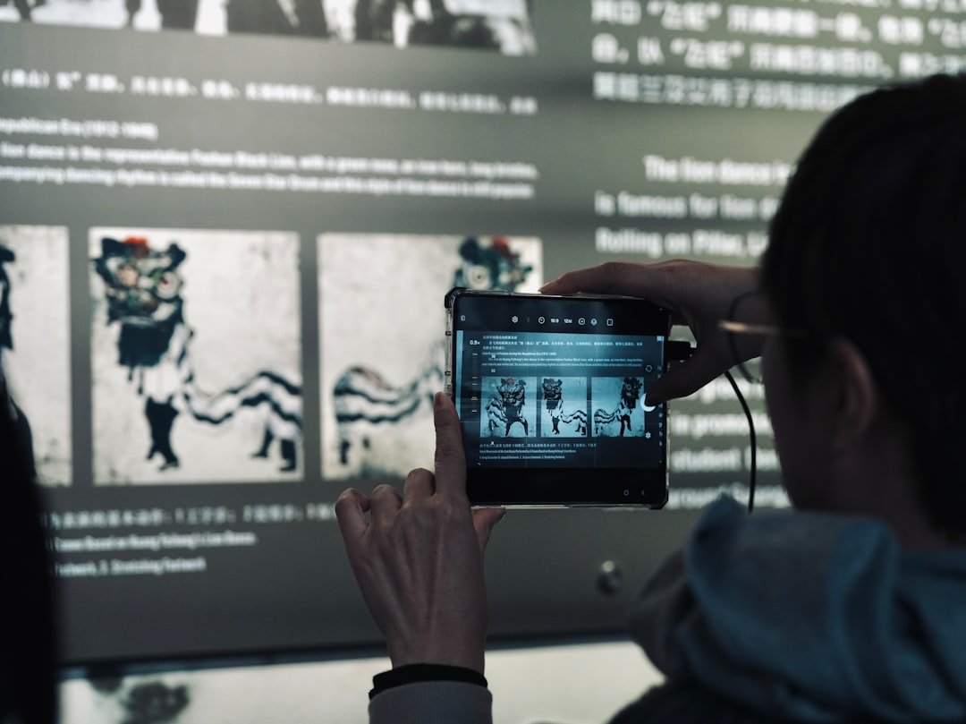 A woman taking a picture of a movie on her phone — Photo by 安 崔士 on Unsplash