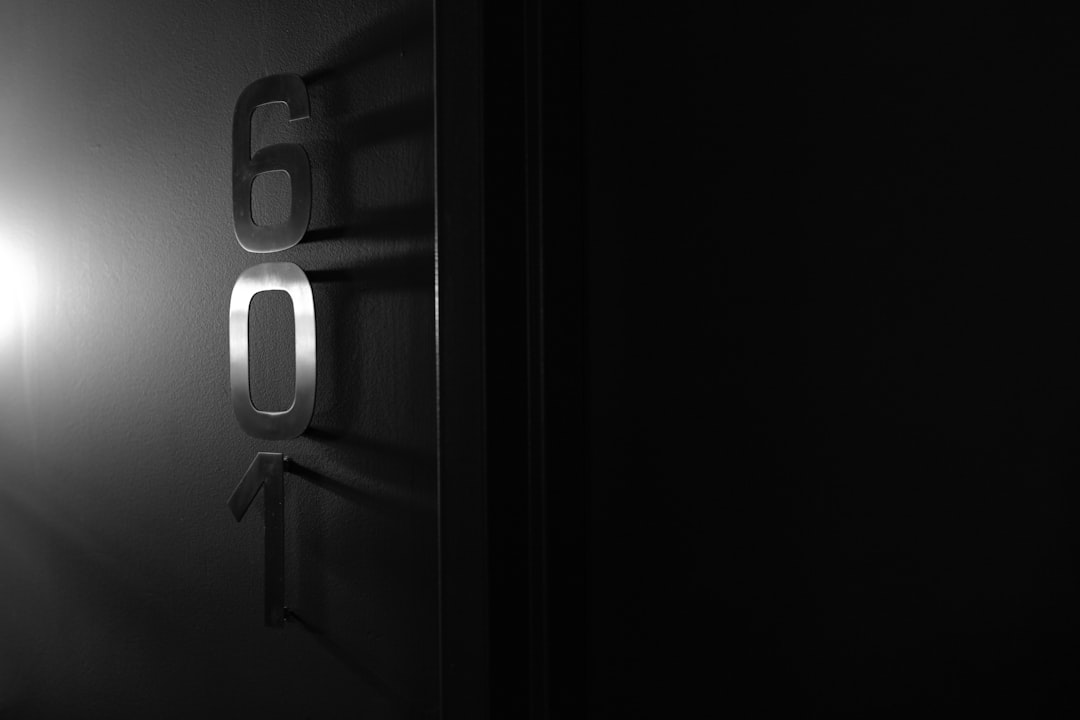 a black and white photo of a door with the number sixty on it — Photo by Steve Pancrate on Unsplash